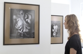 Jedna z návštěvnic obdivuje snímky Jana Saudka.