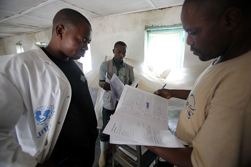 Ředitel zdravotnického centra Kakemenge Masumbuko Mupasula prochází zdravotní dokumentaci se svými kolegy. Pomoc Člověka v tísni si pochvaluje.