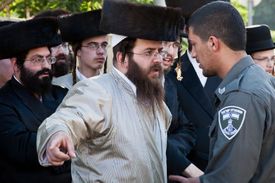 Ultraortodoxní židé v Jeruzalémě se dohadují s policistou.