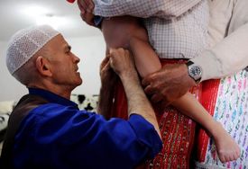 Obřízku na tomto snímku z Bosny dělá holič. Asi má ostřejší břitvu než lékaři v nemocnici skalpel...