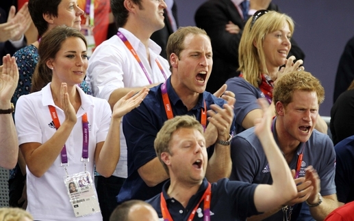 Bylo by s podivem, kdyby se na olympiádě v Londýně neobjevila královská rodina. Zleva v bílém tričku vévodkyně z Cambridge Kate, uprostřed její manžel princ William a vpravo jeho bratr princ Harry.