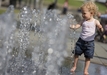 Když už ne na koupaliště, tak aspoň osvěžit ve fontáně. Děti v Berlíně vodotrysky doslova přitahovaly. (Foto: ČTK/AP)