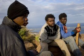 Tři Afričané čekají v kopcích nedaleko Melilly na vhodnou příležitst proniknout do EU.