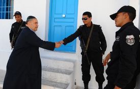Židé jsou v Tunisku ohrožený druh. Na snímku Žid u mešity na Džerbě, kterou musejí hlídat policisté.