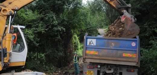 Vodohospodáři pomocí bagru a buldozeru obnažovali porušené potrubí.
