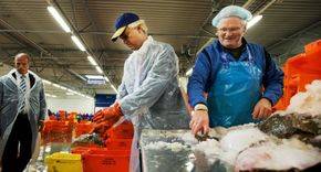 Wilders (uprostřed) na rybím trhu v Urku v rámci své předvolební kampaně. 