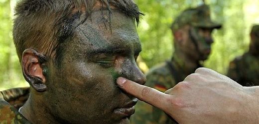 Nováčci německé armády se učí maskování.