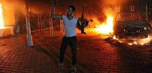 Muž se zbraní v hořícím kozulátu USA v Benghází.