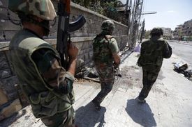 Vládní vojáci střeží jednu ze čtvrtí Alepa. 