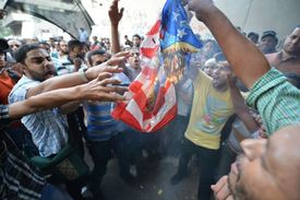 Demonstranti pálí vlajku USA před americkou ambasádou v Káhiře.