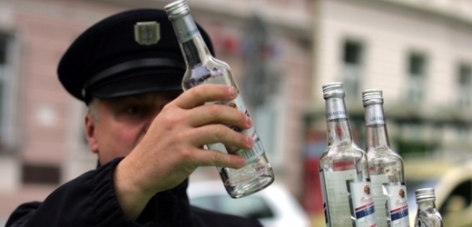 Policista odebírající vzorky z lahve vyrobené Likérkou Drak.