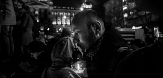 Vítězná černobílá fotografie zachycuje muže, který rozsvěcí svíčku na jednom z pietních míst, jež po smrti Havla spontánně vznikla, na Václavském náměstí v Praze (autor: Milan Jaroš, Respekt).