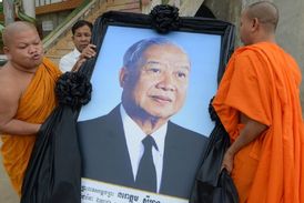 Budhističtí mniši s obrazem Sihanuka v Kambodži.