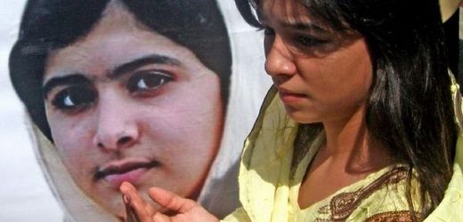 Pákistánská dívka u fotografie těžce zraněné Malalaj. 