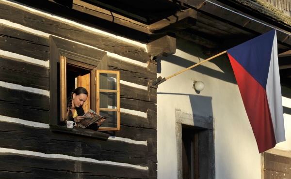 Členka volební komise v obci Stanový na Jablonecku si krátí čekání na voliče čtením při západu Slunce.