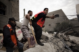 Palestinští hasiči zachraňují z trosek raněné.