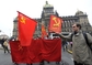Rudými vlajkami se symboly komunismu srpem a kladivem se prezentovali příznivci KSČM.