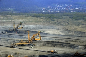 Povrchový uhelný důl, v pozadí je těžbou ohrožená obec Horní Jiřetín.
