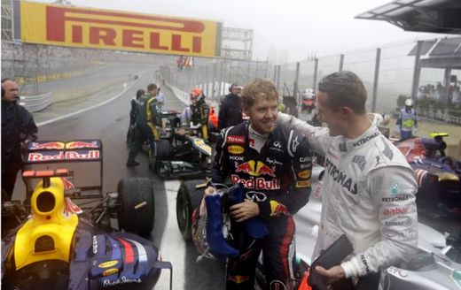 Michael Schumacher (vpravo) gratuluje Sebastianu Vettelovi.