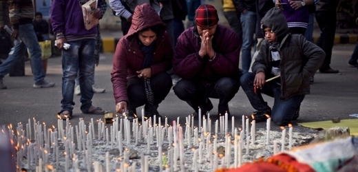 Indická rodina zapaluje svíčky za oběť skupinového znásilnění.