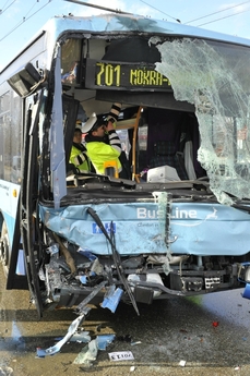 Policisté fotografují stav autobusu po nehodě.