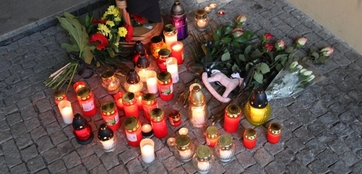 Lidé na místě tragédie zapalují svíčky.