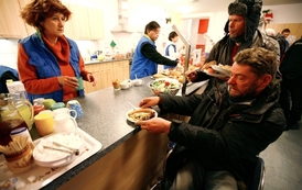 Bezdomovci dostávají jídlo v Berlíně.