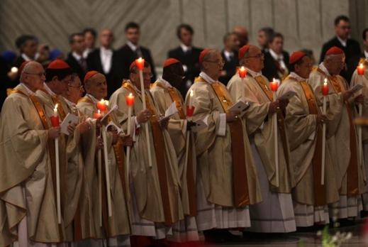 Kardinálové drží svíčky během bohoslužby vedené papežem.