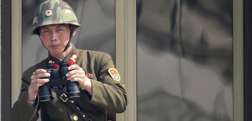 Severokorejský voják se dívá za hranice.