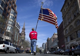 Američan s americkou vlajkou na Boylston Street. V těchto místech vybuchly bomby při bostonském maratonu.
