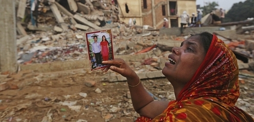 Bangladéšská žena drží fotku svého pohřešovaného manžela, kterého pravděpodobně zavalily trosky padající budovy.