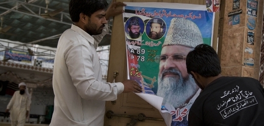Lepení plakátů příznivců sunnitské radikální strany Ahle Sunat Wal Jamaat (ASWJ).
