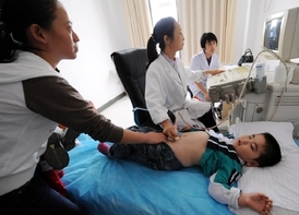Lékařka vyšetřuje čínské dítě, které onemocnělo po vypití kontaminového mléka.