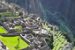 Peruánská hora Machu Picchu na fotografii s návštěvníky, kteří vypadají jako drobné postavičky na stolní hře.