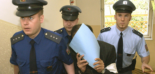 Hámid bin Abdal Sání na cestě k soudu roku 2005 schovává svoji tvář.