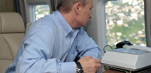Putin se dívá z okna za letu ve svém vrtulníku.