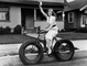 Žena na kole s ořími koly. Nedatovaný snímek.