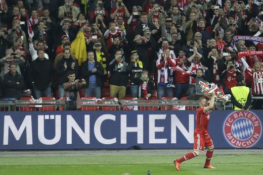 Bastian Schweinsteiger slaví s trofejí pro vítěze před mnichovskými fanoušky.