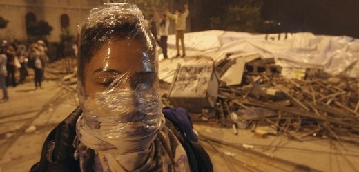 Demonstrantka s igelitem a šátkem na hlavě proti slznému plynu.