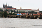 Mostní pilíře z velké části zmizely pod hladinou rozbouřené Vltavy. (Foto: ČTK)