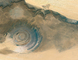 Erodovaná písečná hora v saharské poušti v Mauritánii známá jako struktura Richat. Jde o obří kruh, který měří v průměru asi 50 kilometrů – je tedy téměř dvakrát větší než Praha. Oproti ploše pouště se její tvar i barva odrážejí; kruhový tvar vypadá jako gigantické oko.