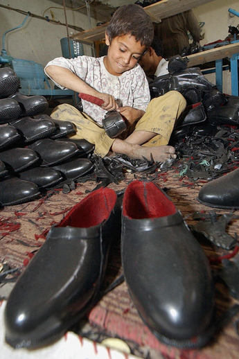 Devítiletý afghánský chlapec Mozamel leští právě vyrobené boty z recyklovaných plastů v továrně v Kábulu. Mozamel je jedním z tisíce dělníků, kteří tu tvrdě pracují, aby si vydělali 1,30 dolaru (asi 26 korun) denně.