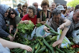 Lide se sápou po zeleninně rozdávané zdarma farmáři v Aténáhc.