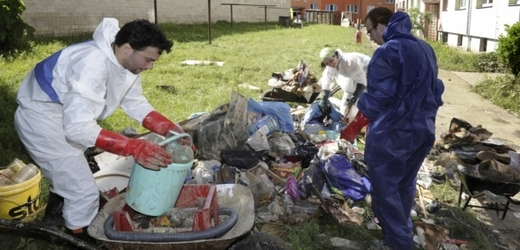 Na Střekovském nábřeží v Ústí nad Labem lidé vyklízejí a odvážejí zatopené věci ze sklepů, které se následně čistí.