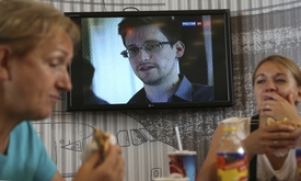 Dámy se posilňují na letišti Šeremetěvo. Za nimi Snowden, ale jen v televizi.