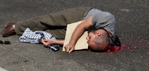 Mrtvý muž před kasárnami republikánské gardy v Egyptě. Má střelnou ránu v hlavě.