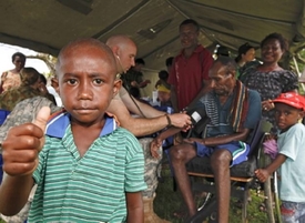 Lékař australského vojenského loďstva ošetřuje pacienty; Papua-Nová Guinea..