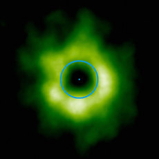 Oblast bohatá na oxid uhelnatý okolo hvězdy TW Hydrae, jak ji zachytila soustava radioteleskopů ALMA. Modrý kruh odpovídá oběžné dráze Neptuna okolo Slunce.