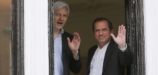 Assange mává z okna ekvádorské ambasády v Londýně, která je trvale obklíčená policisty.
