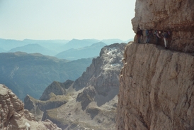 Na uzoučkých skalních římsách v závratných výškách přijde vhod železné lano, k němuž se lze jistit pomocí úvazů a karabin. Na snímku via ferrata obepínající pohoří Brenta nad italským městečkem Madonna di Campiglio.